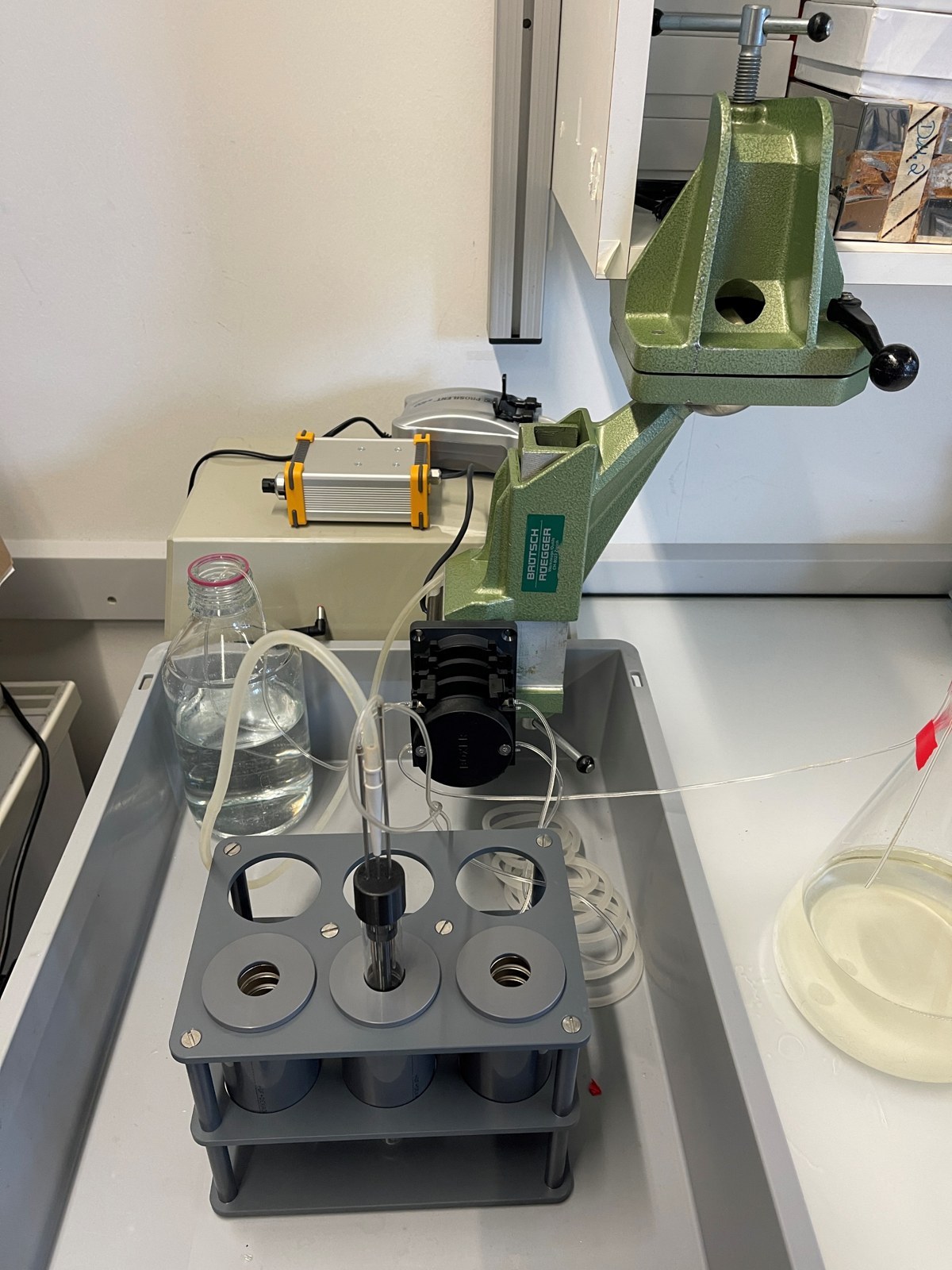 MAD bioreactor setup with a glass culture tube inside a magnet rack, connected to media and pumps
